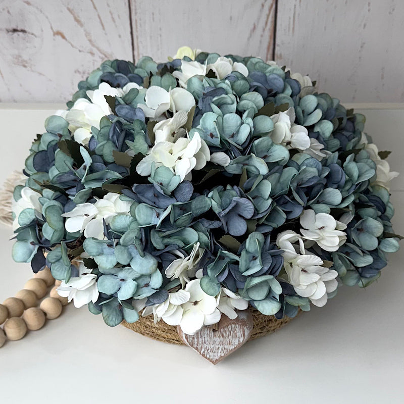 CESTO REDONDO M EM PALHA COM HORTÊNSIAS AZUIS ENVELHECIDAS E CORAÇÃO DE MADEIRA 16AX32L/CM